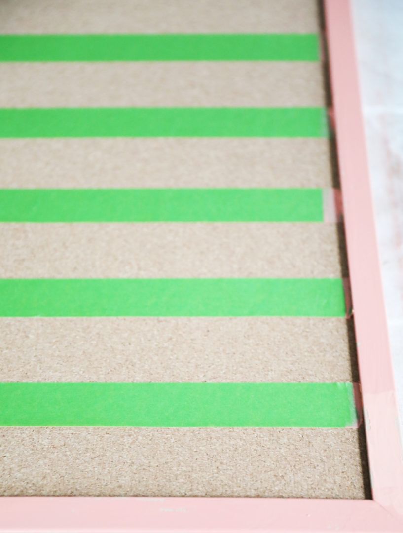 Horizontal strips of Green FrogTape Multi-Surface Painter's Tape taped across the inside of a wooden frame