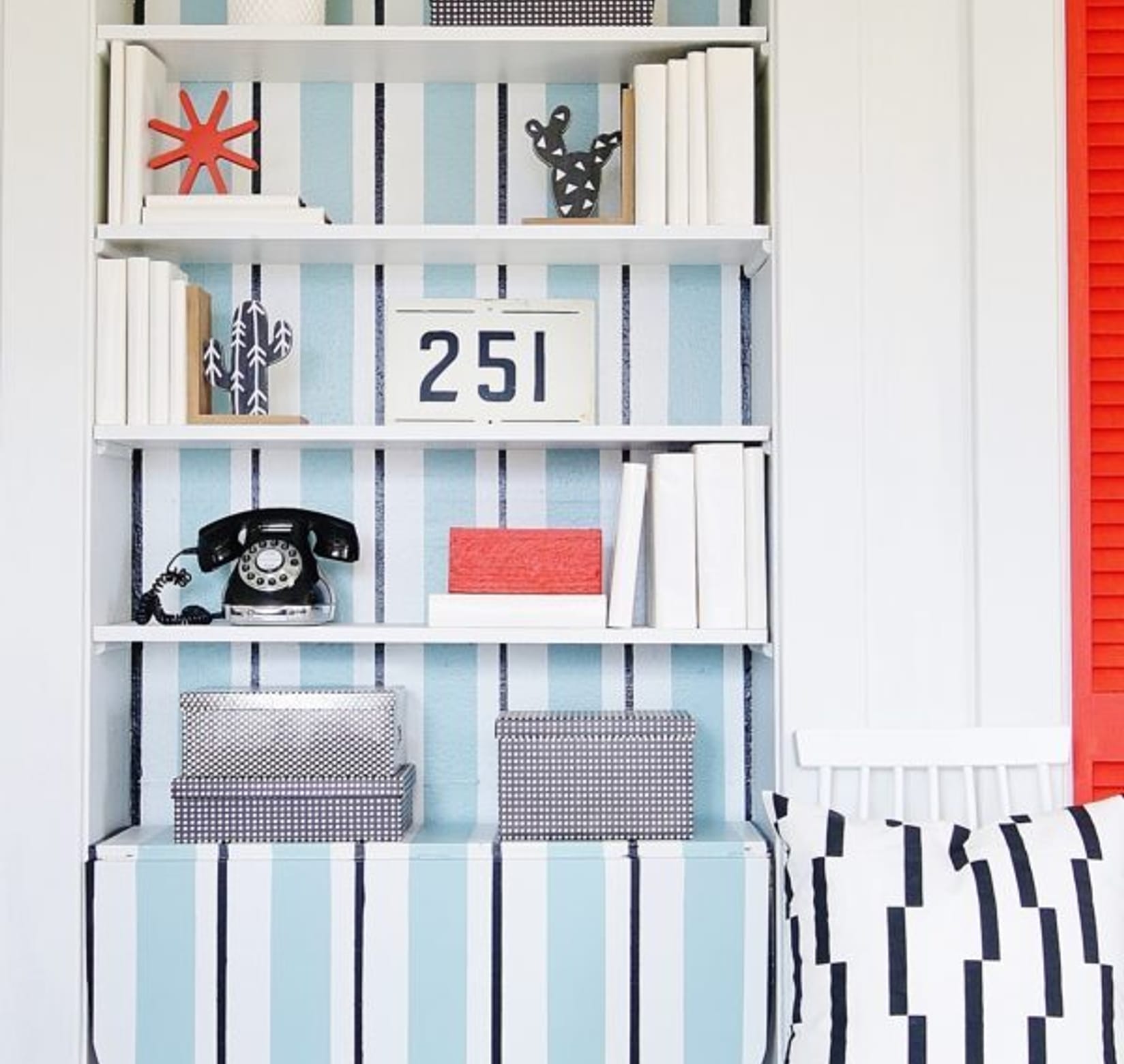 Built in book shelf with white, black, and light blue lines running vertically.