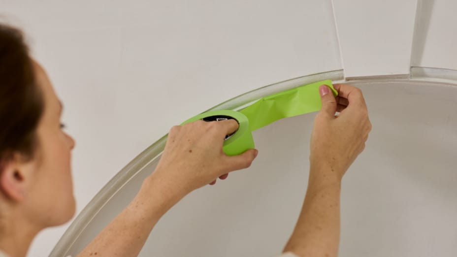 A woman applying Green FrogTape Advanced to a curved archway