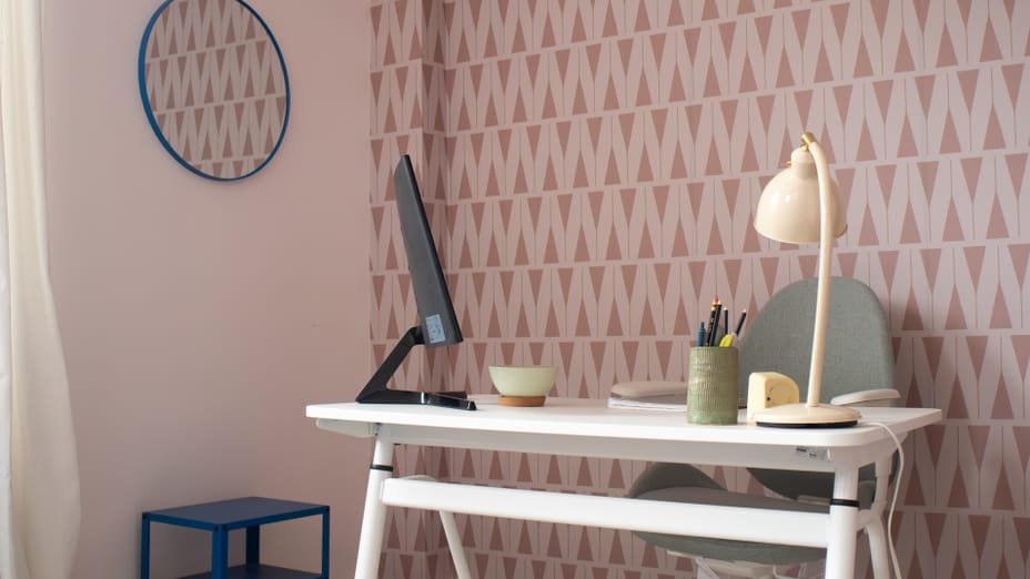 A Desk set up with a wallpapered background