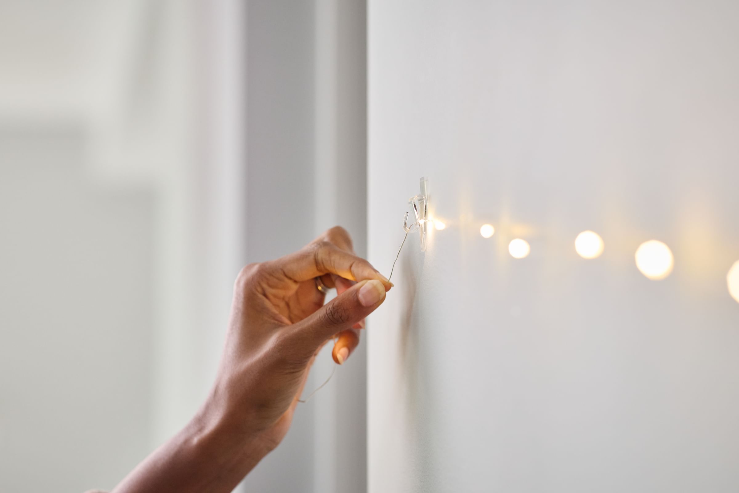 Lights being hung on FrogTape reMOVEables Clear Mini Hooks