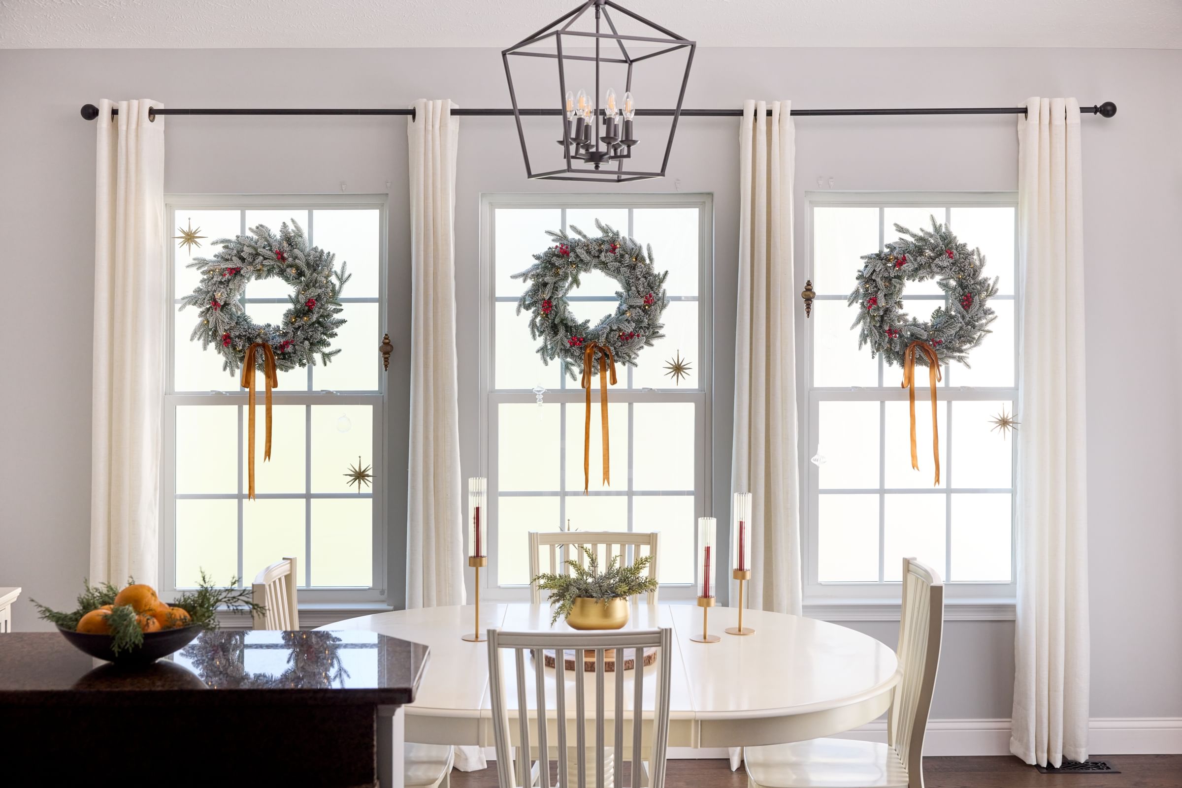 Holiday Wreathes displayed on windows, hung with FrogTape reMOVEables hooks