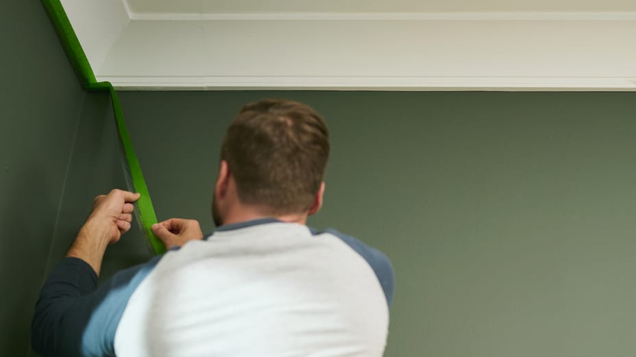 Man Peeling FrogTape off of ceiling moulding