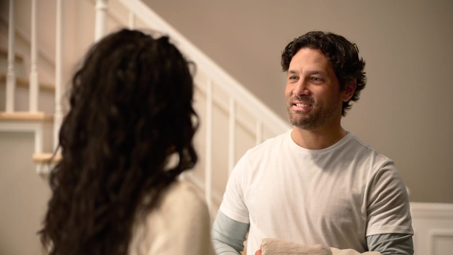 A Painter holding a drop cloth talking with a client