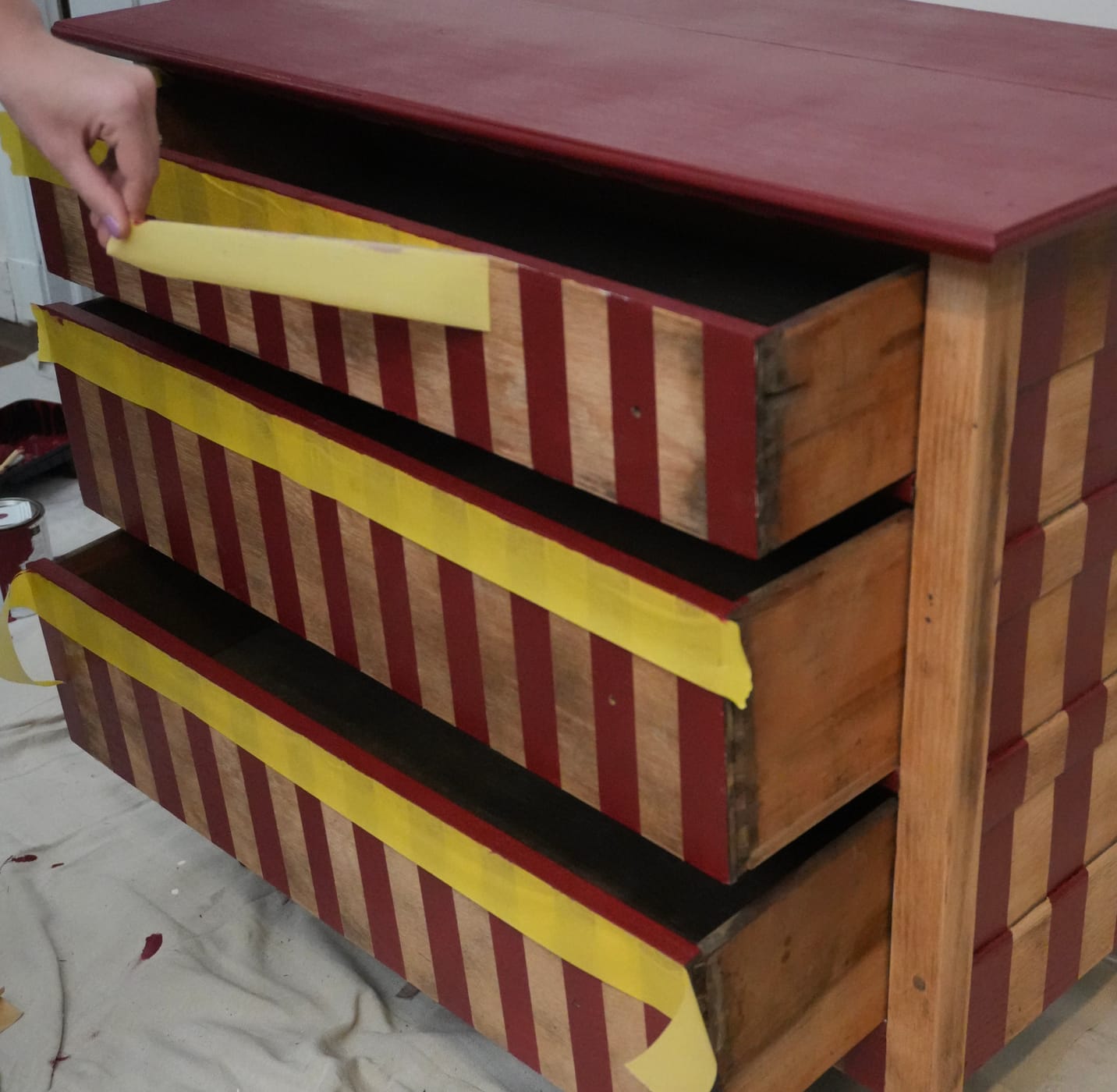 Yellow FrogTape Delicate Surface Painter's Tape being removed from a freshly painted dresser drawer