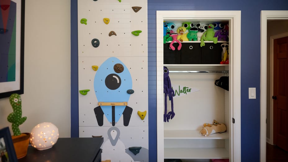 Bedroom wall with closet and rocket ship themed rock climbing wall