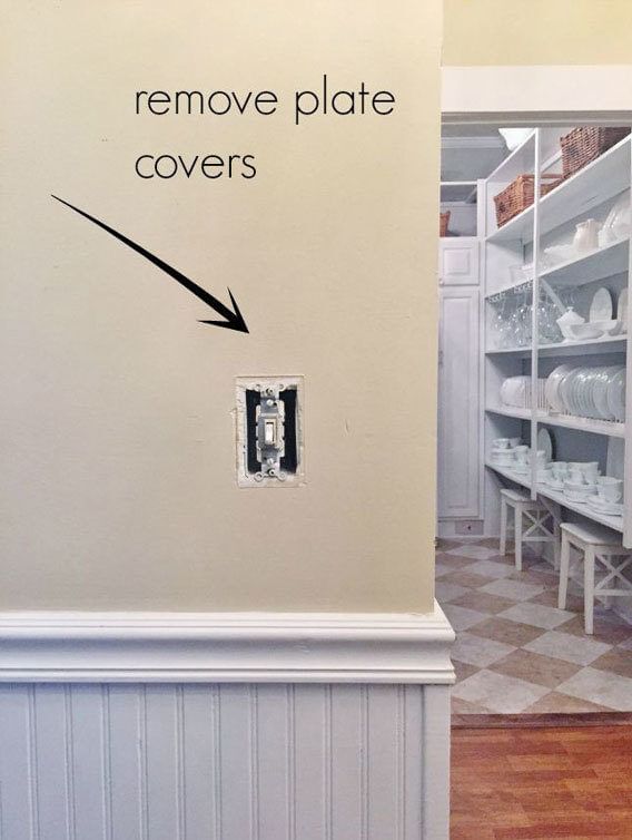 Remove plate covers, arrow pointing at a light switch on a wall without the cover