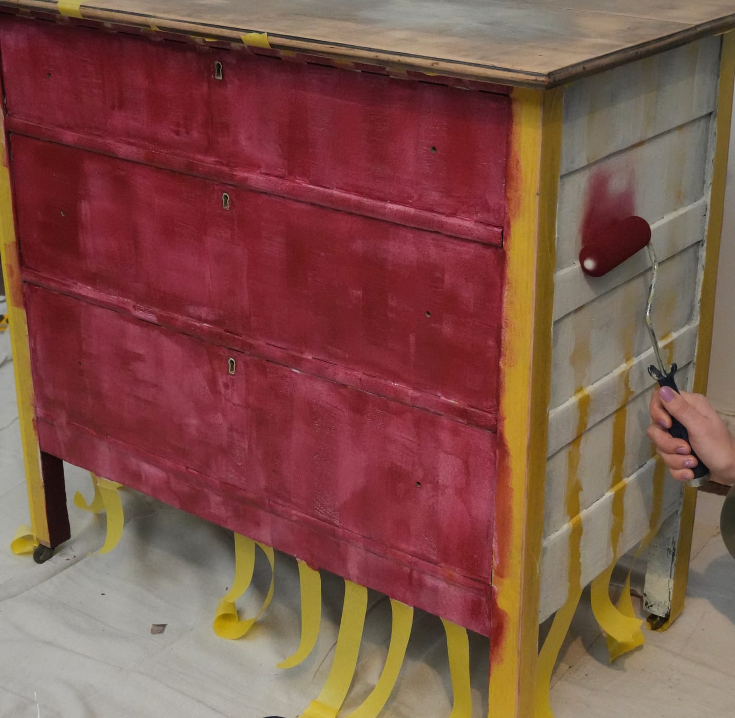 An old dresser being painted red