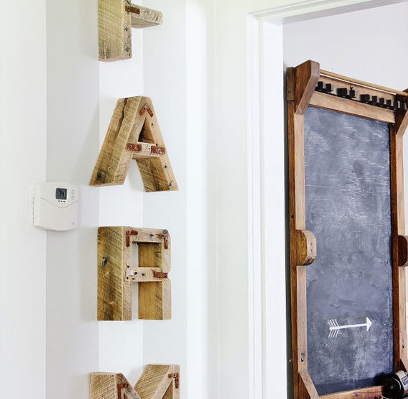 Farm is spelled out in wooden letters descending vertically on a gray and white striped wall