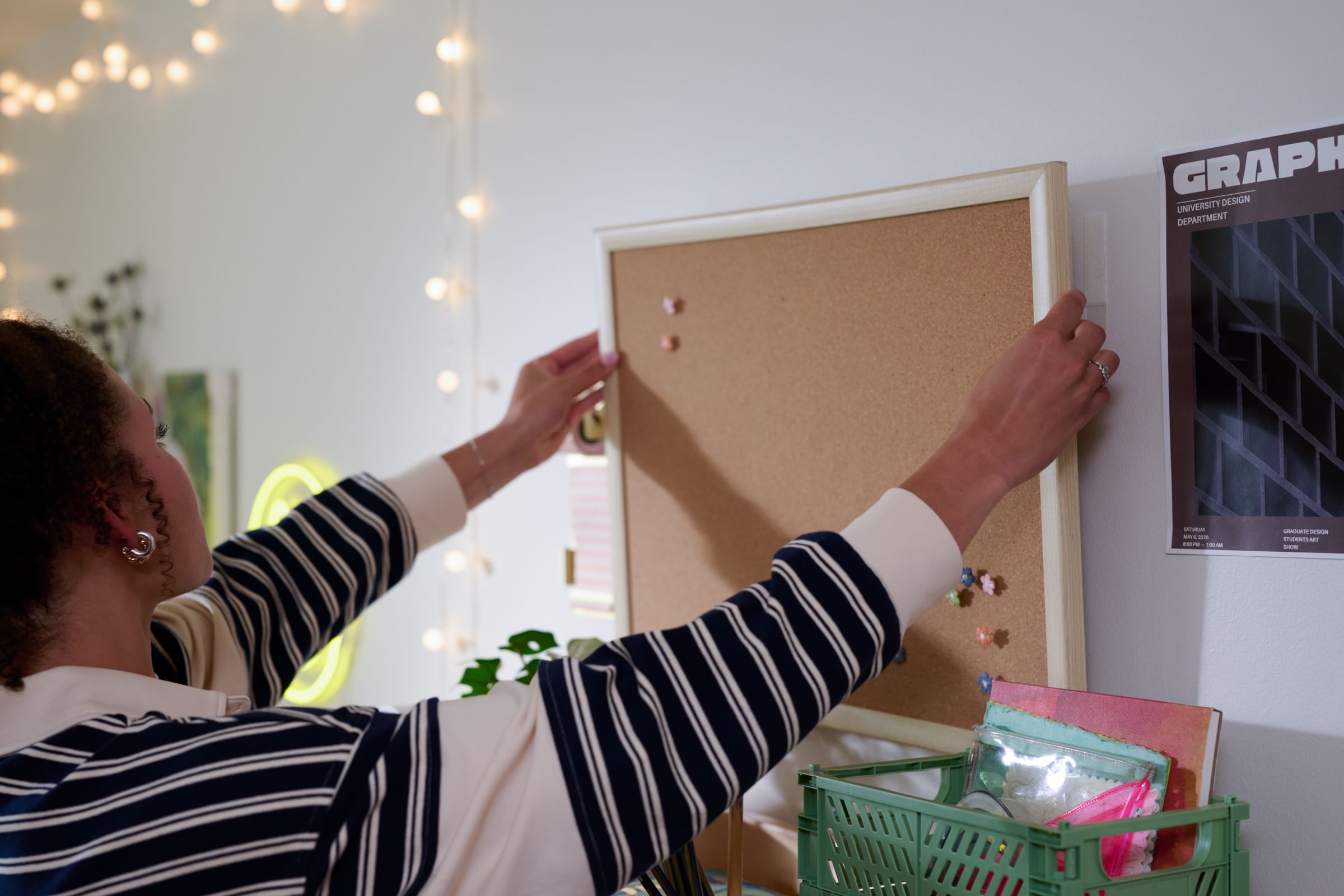 Corkboard in a dorm, being hung with FrogTape reMOVEables Large Picture Hanging Strips