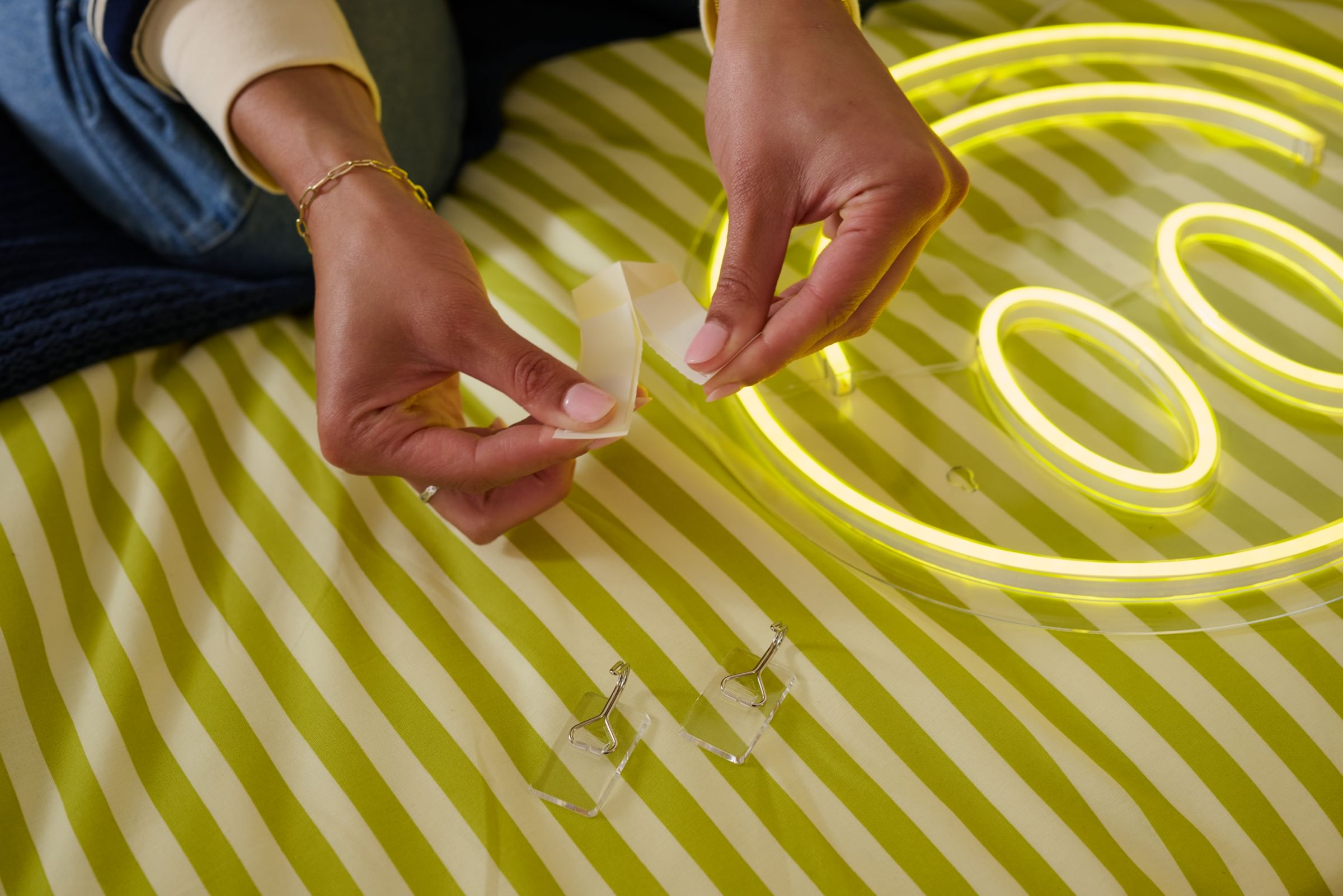 Smiley face LED sign in a dorm, hung with FrogTape reMOVEables Clear Wire Hooks