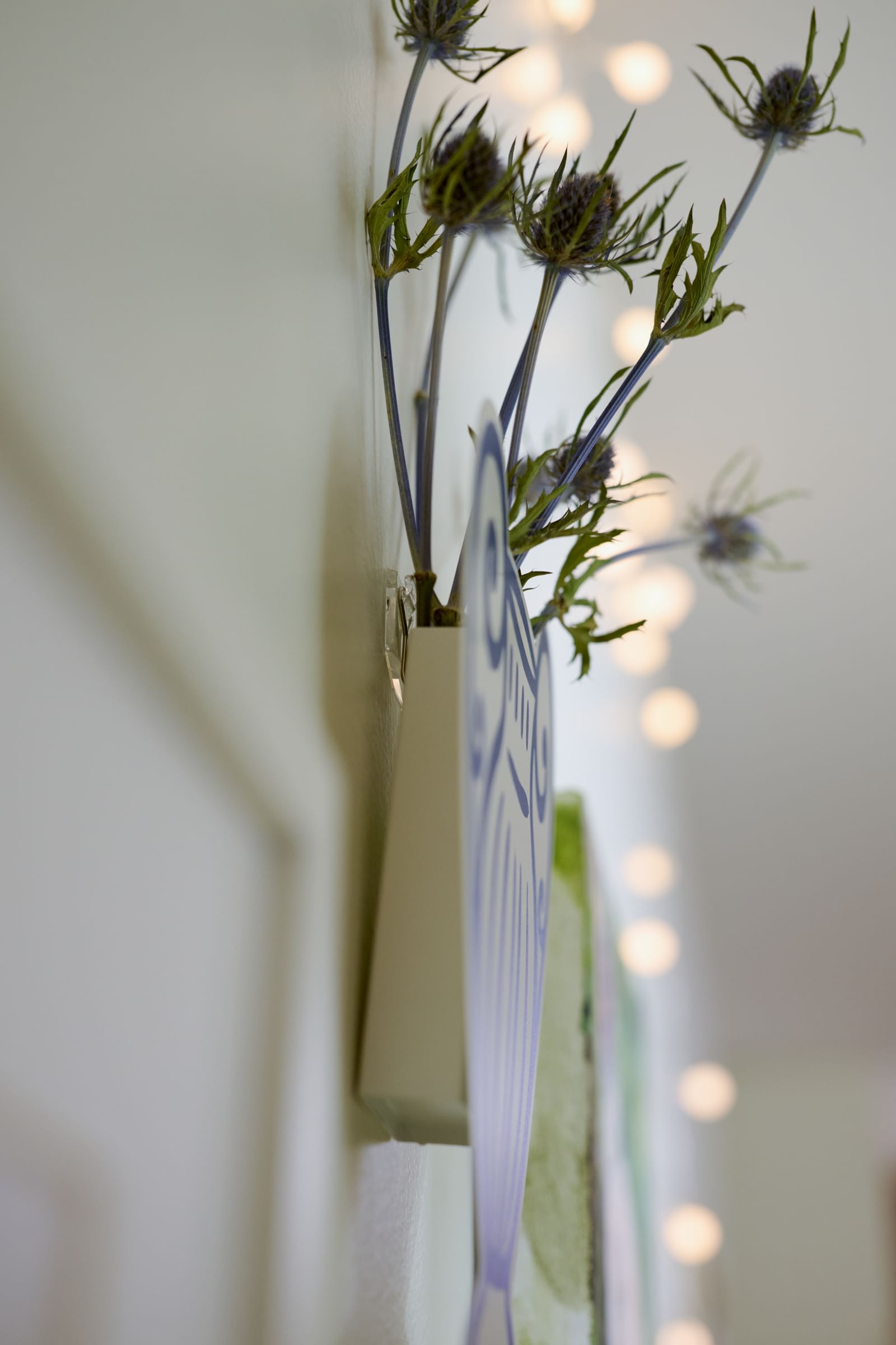 Flowers and vase hanging in a dorm, hung with FrogTape reMOVEables Large Picture Hanging Strips