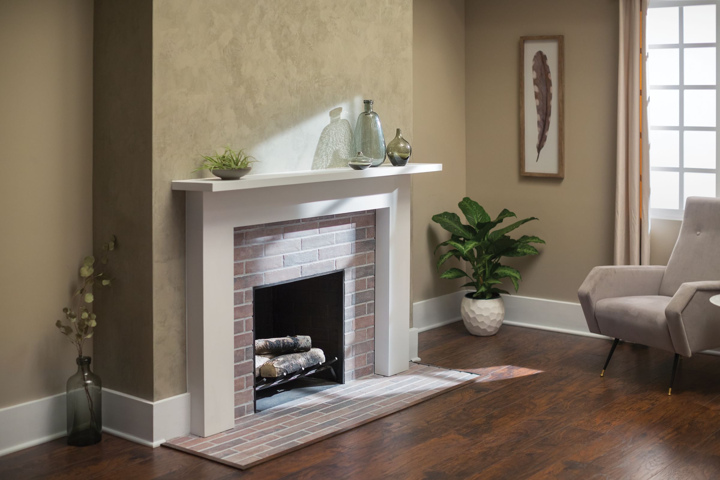 Fireplace in a living room area, there is a plant in the corner, and some vases on the mantel.