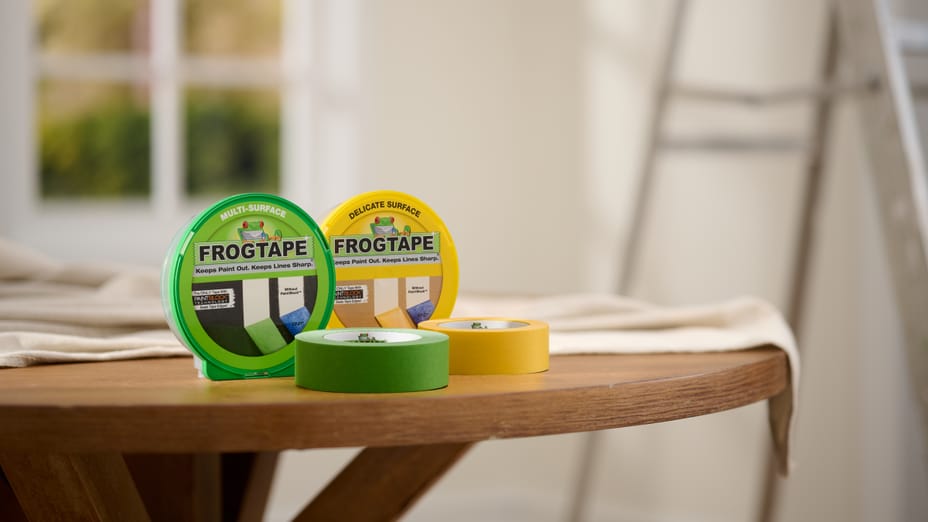 Green FrogTape Multi-Surface Painter's Tape and Yellow FrogTape Delicate Surface Painter's Tape on a round wooden table