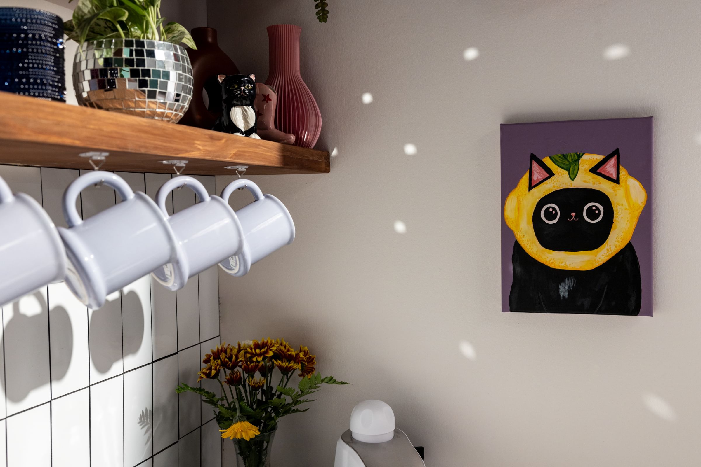 Four Mugs hung under a kitchen shelf using FrogTape reMOVEables