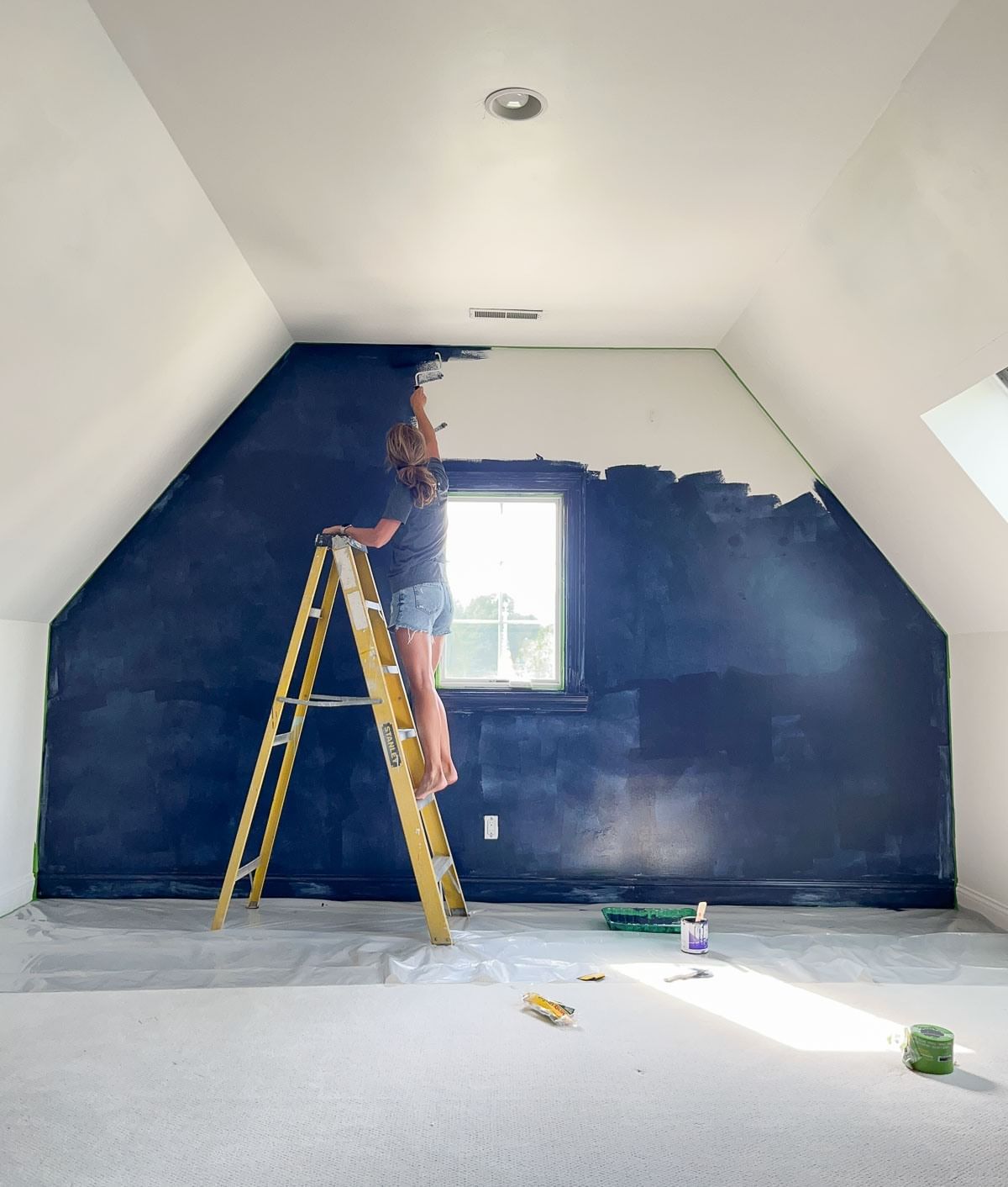 Step 1: Woman on ladder painting entire wall blue