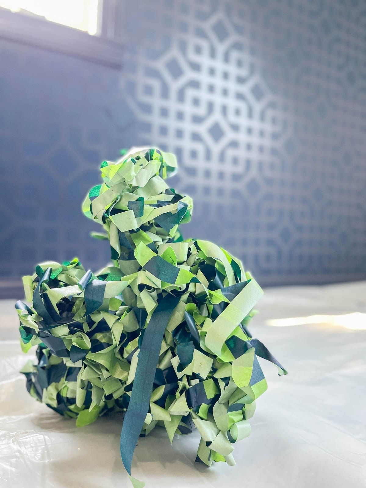 Used FrogTape on a white Drop Cloth. The back wall is dark blue and has an intricate geometric pattern.