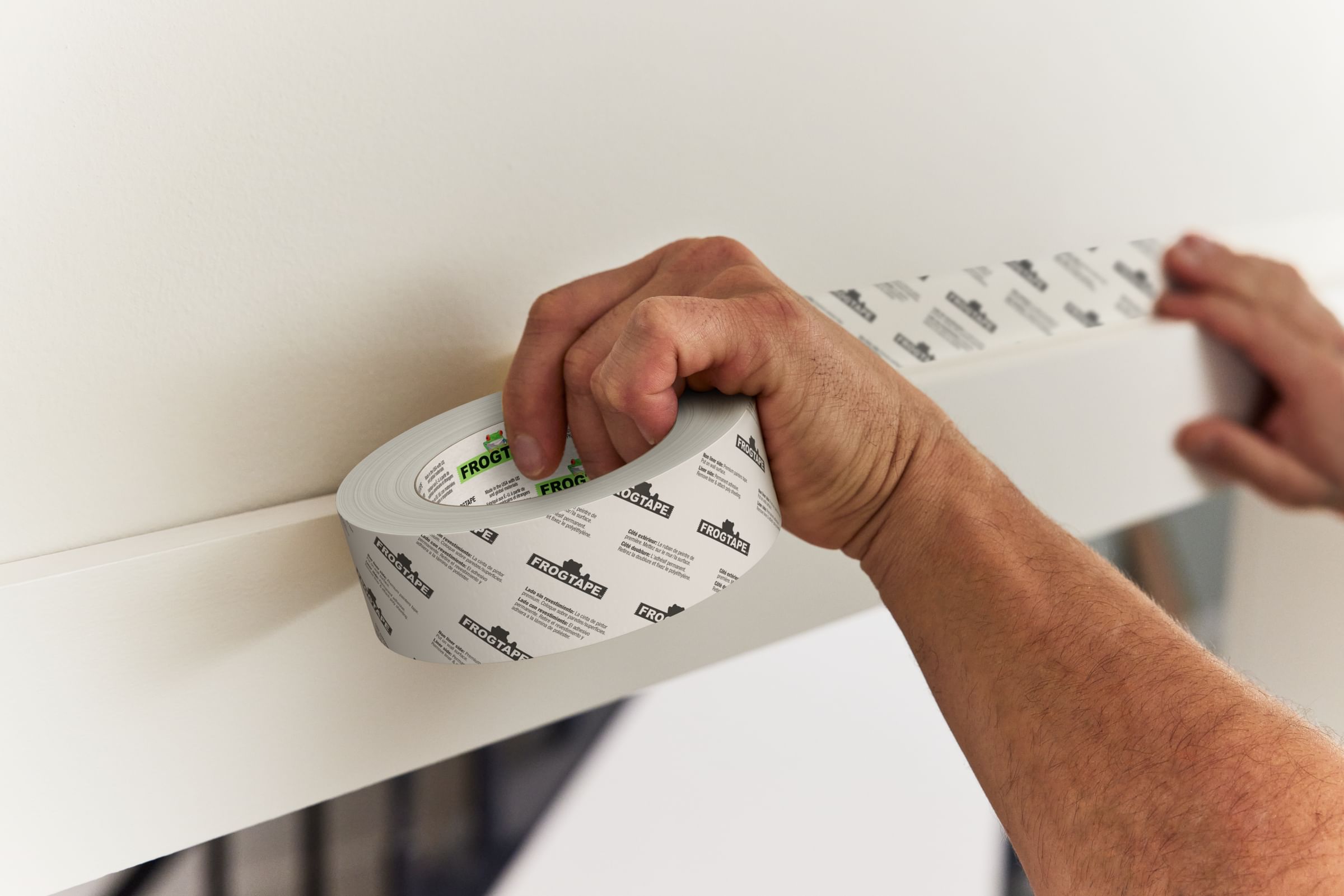 FrogTape Double Sided Poly-Hanging Containment Tape being applied to the top of a door frame