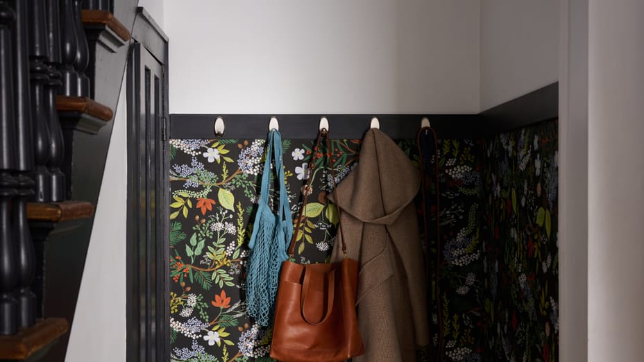 Five FrogTape reMOVEables Brushed Nickel Hooks hanging in a foyer. Hanging are a couple bags, a Jacket, and a Leash.