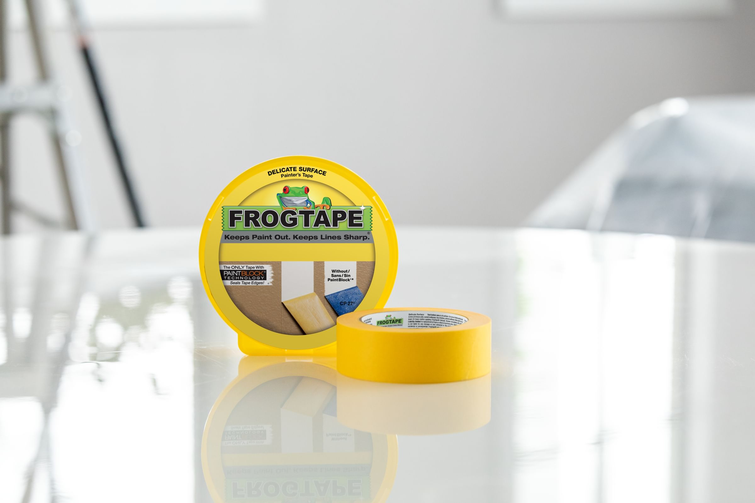 A Canister and Roll of Yello FrogTape Delicate Surface Painter's Tape on a white Table