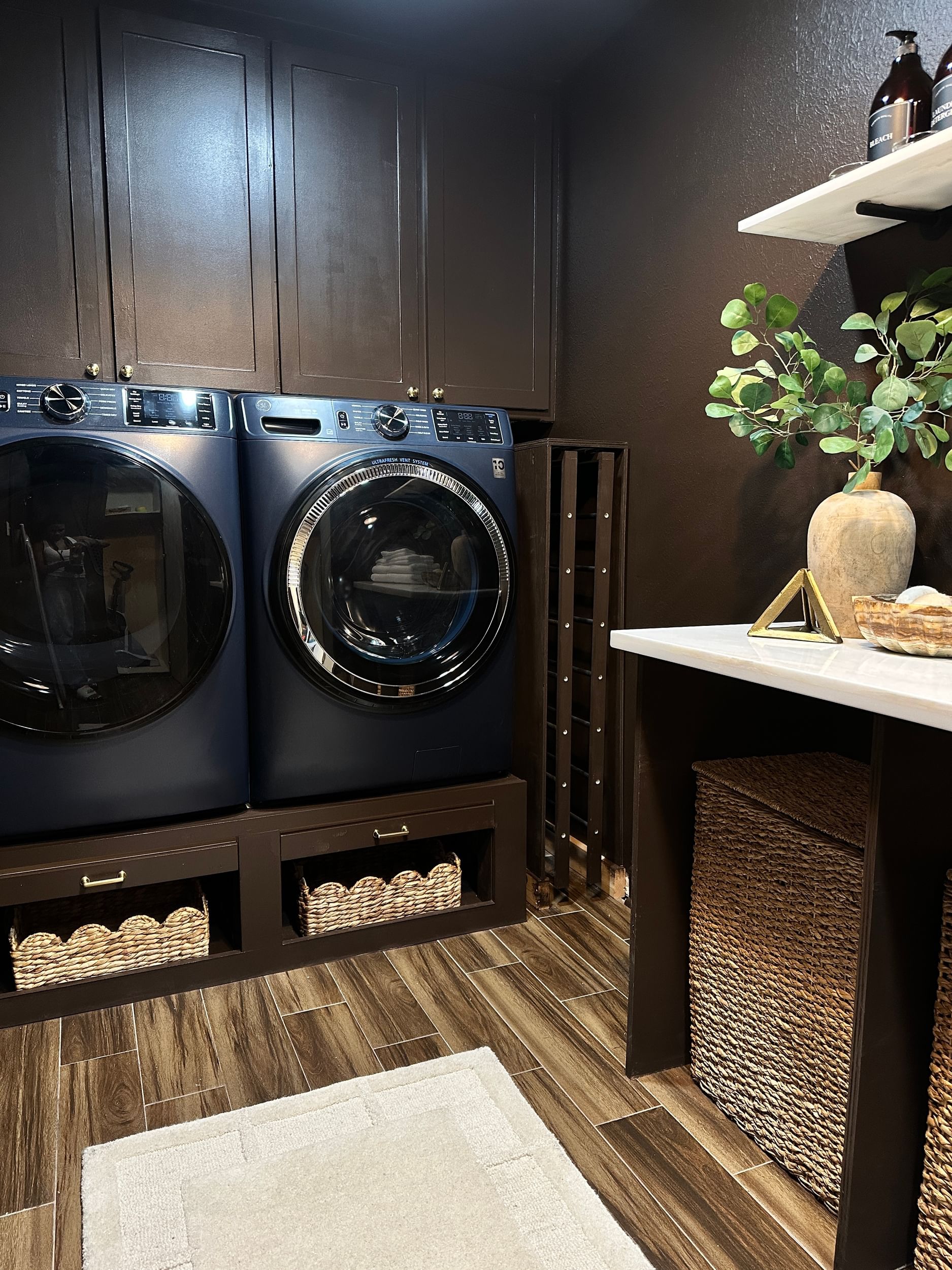 A brown color drenched laundry room with a modern blue washer and dryer