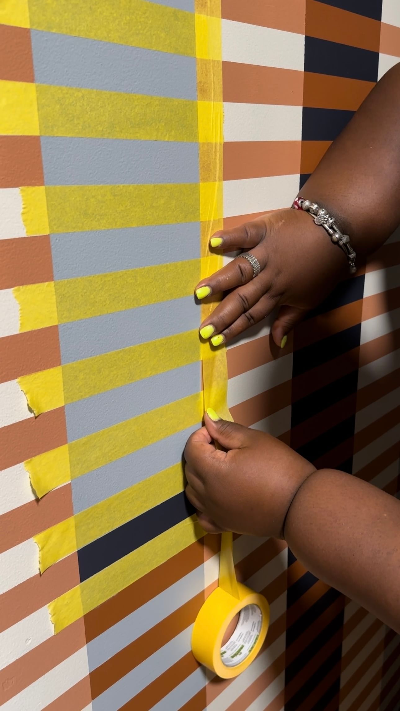 Kayla Nelson Taping off sections of her Mural with Yello FrogTape Delicate Surface Painter's Tape
