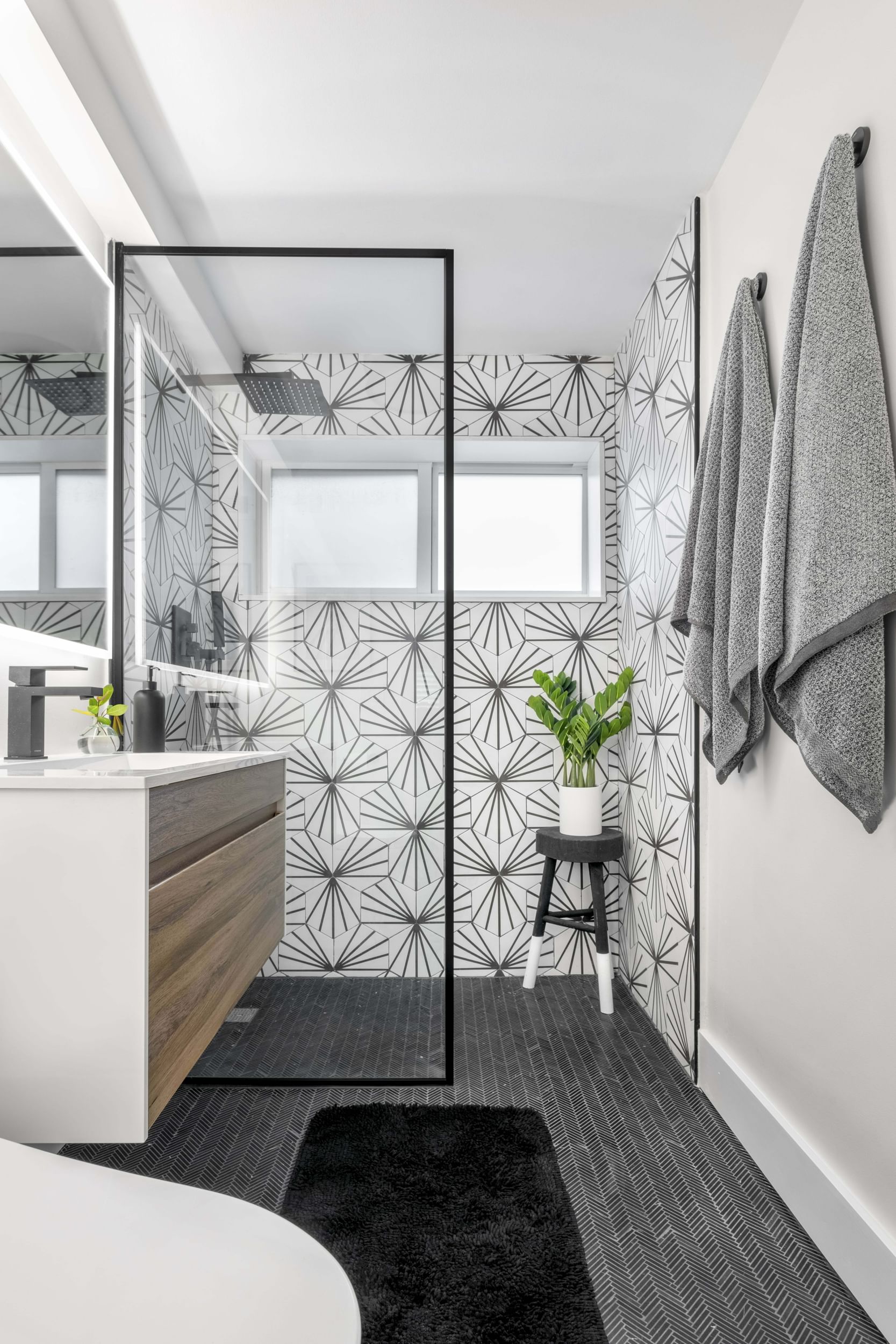 White and gray bathroom with a glass shower divider