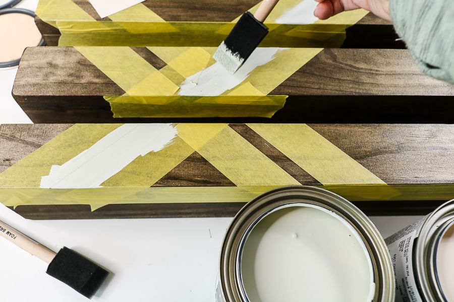 wooden shelves with yellow FrogTape Delicate Surface Painter's Tape being painted with white paint
