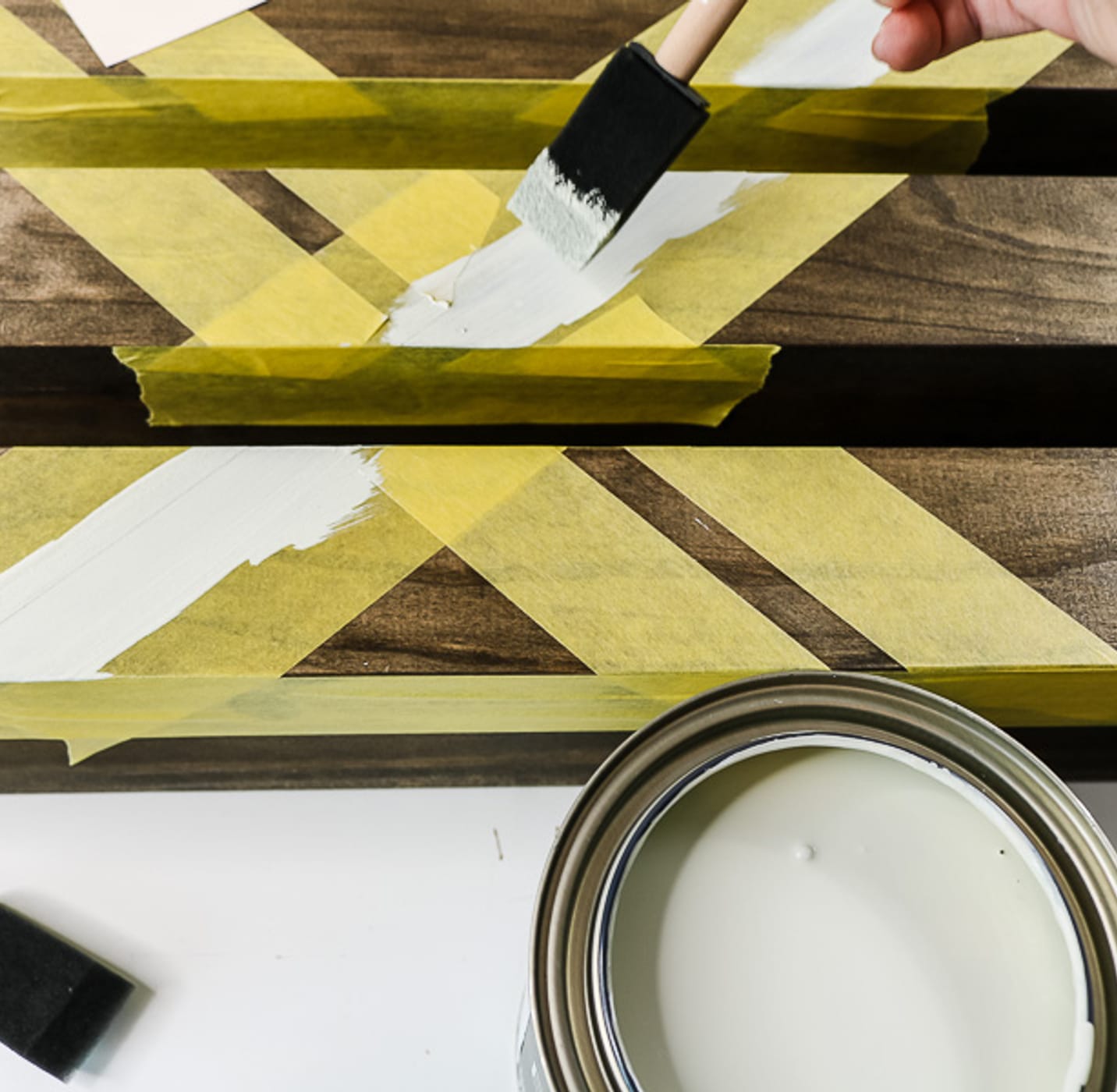 wooden shelves with yellow FrogTape Delicate Surface Painter's Tape being painted with white paint