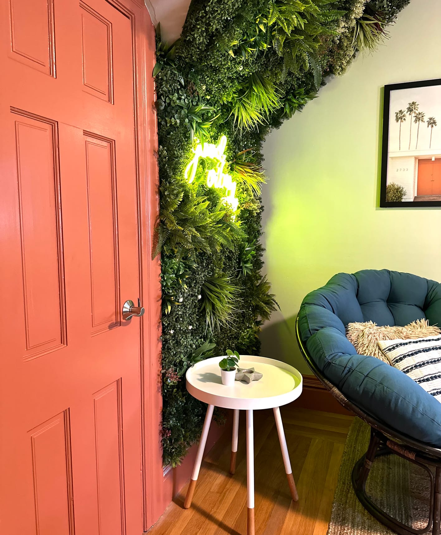 Interior orange painted door peaking into casual, bohemian sitting room