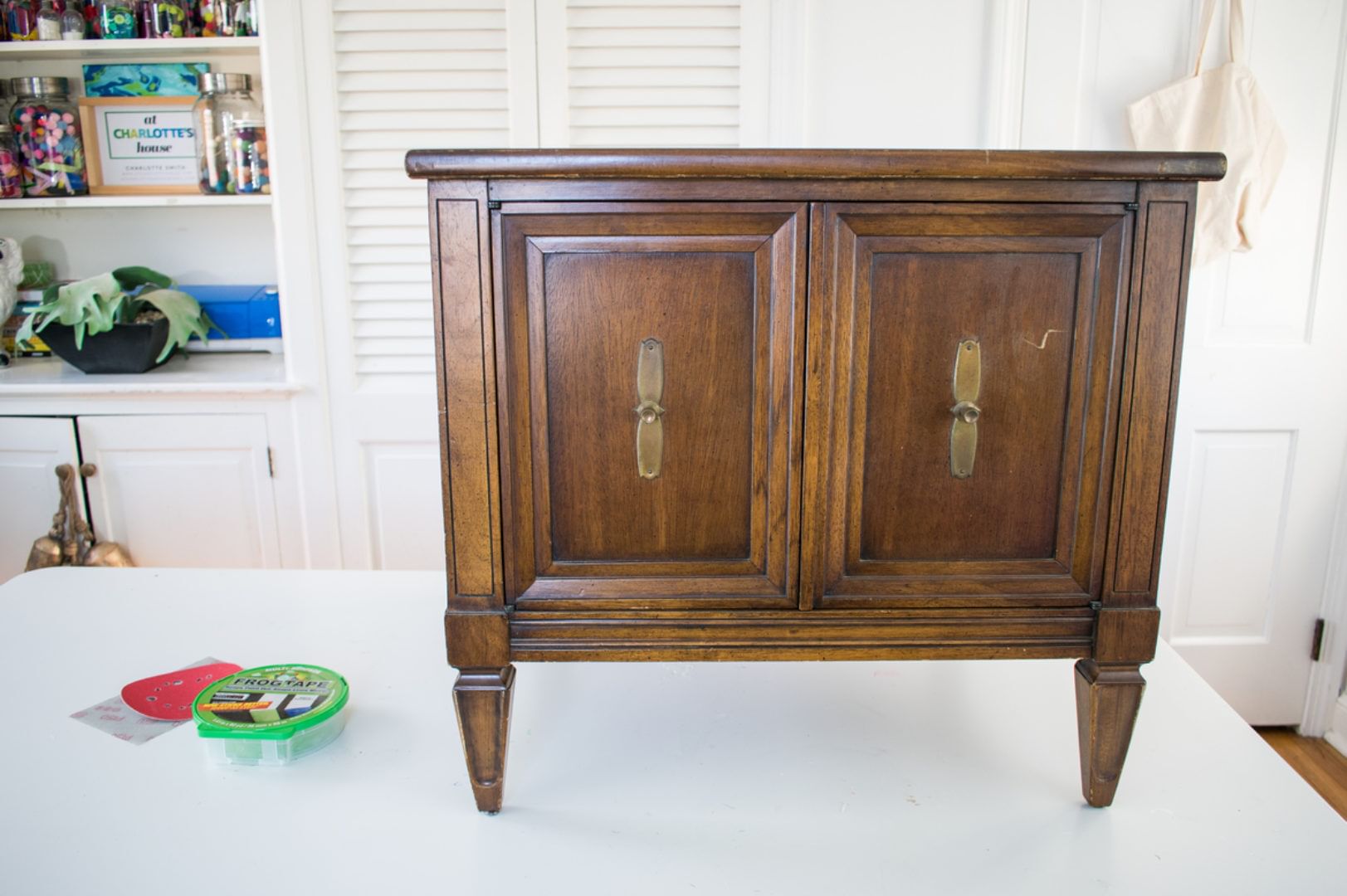 A small wooden end table with two cabinet doors