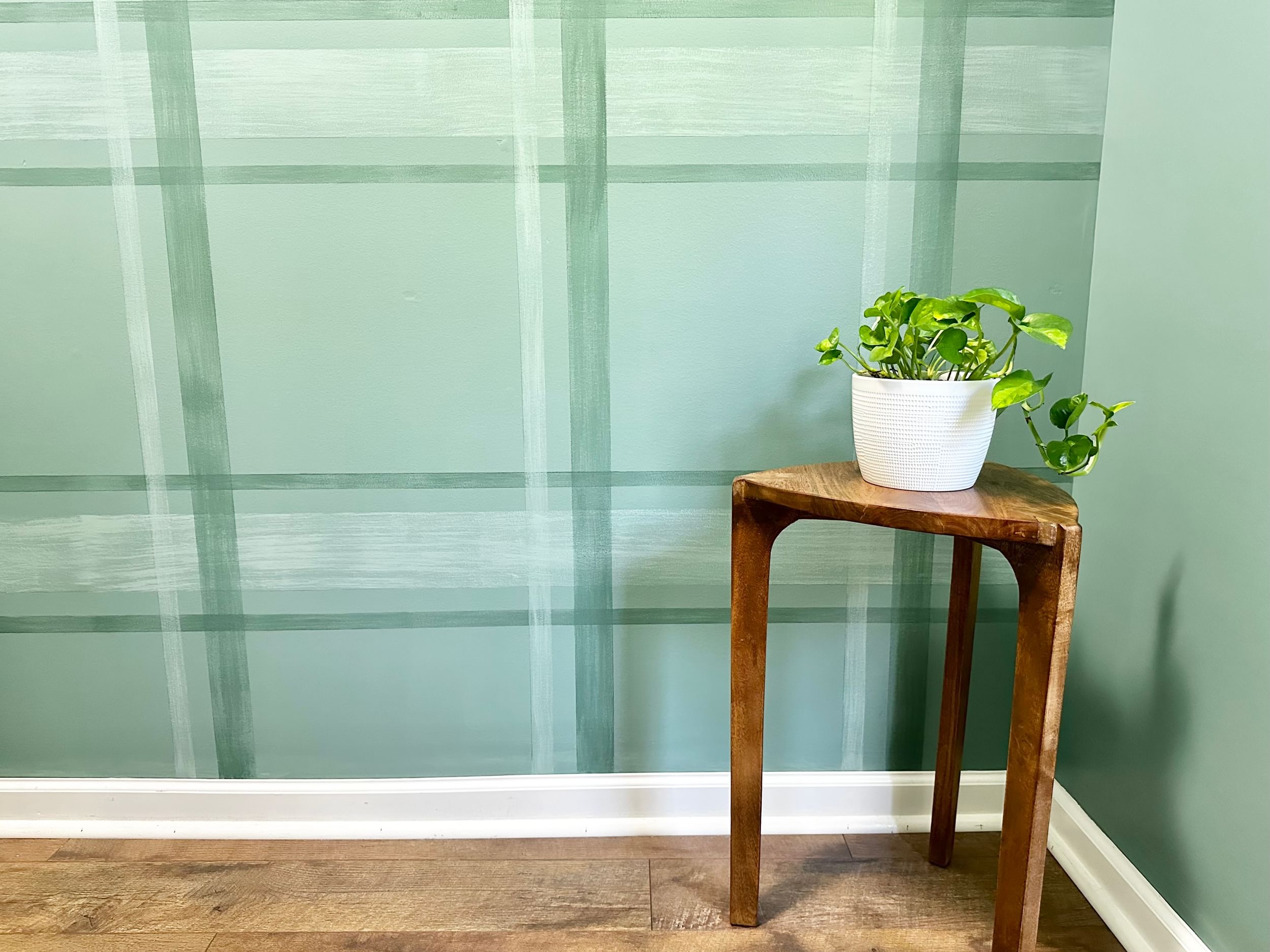 Blue Green Plaid Room with small wooden end table with plant on it.