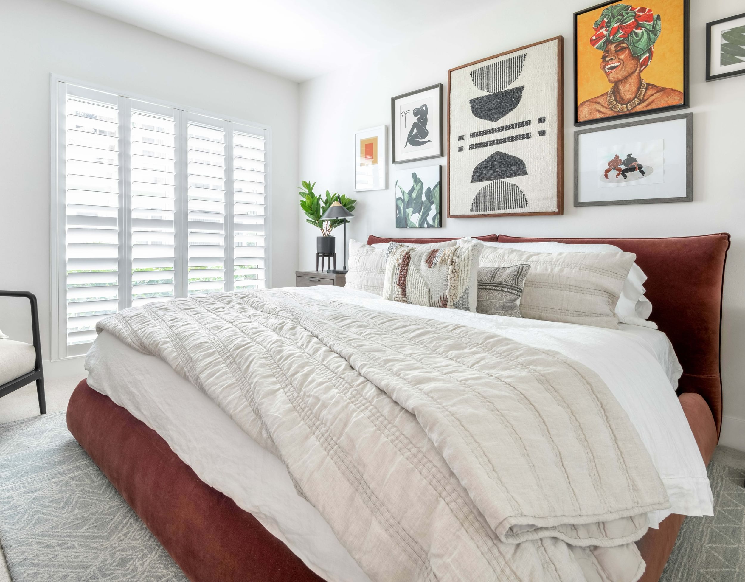 Large bed with fluffy bedspread and art hanging above