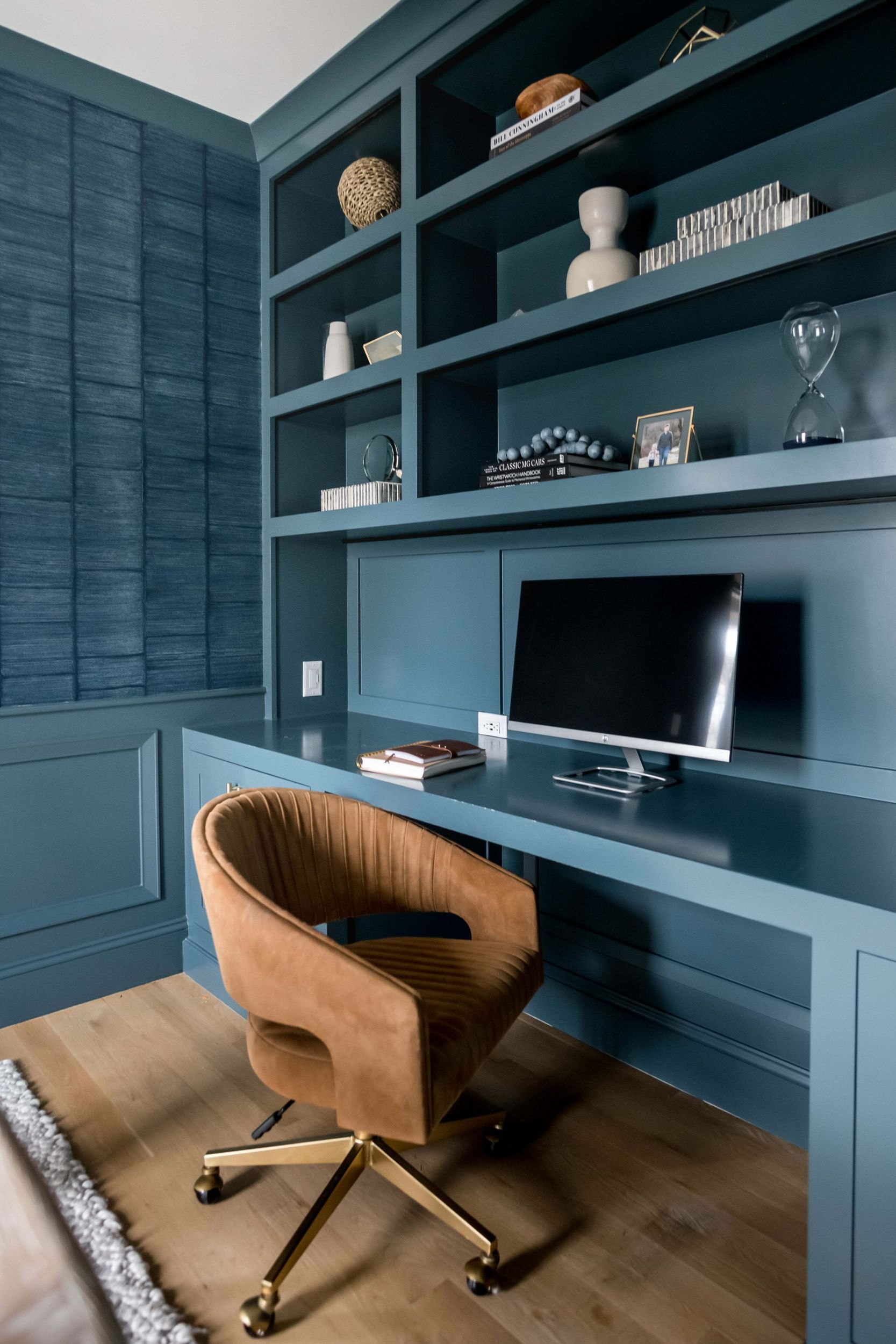 Blue desk with blue shelves and a brown desk chair