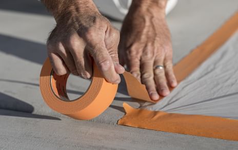 FrogTape Pro Grade Orange Painter's Tape Masking a drop cloth to the ground