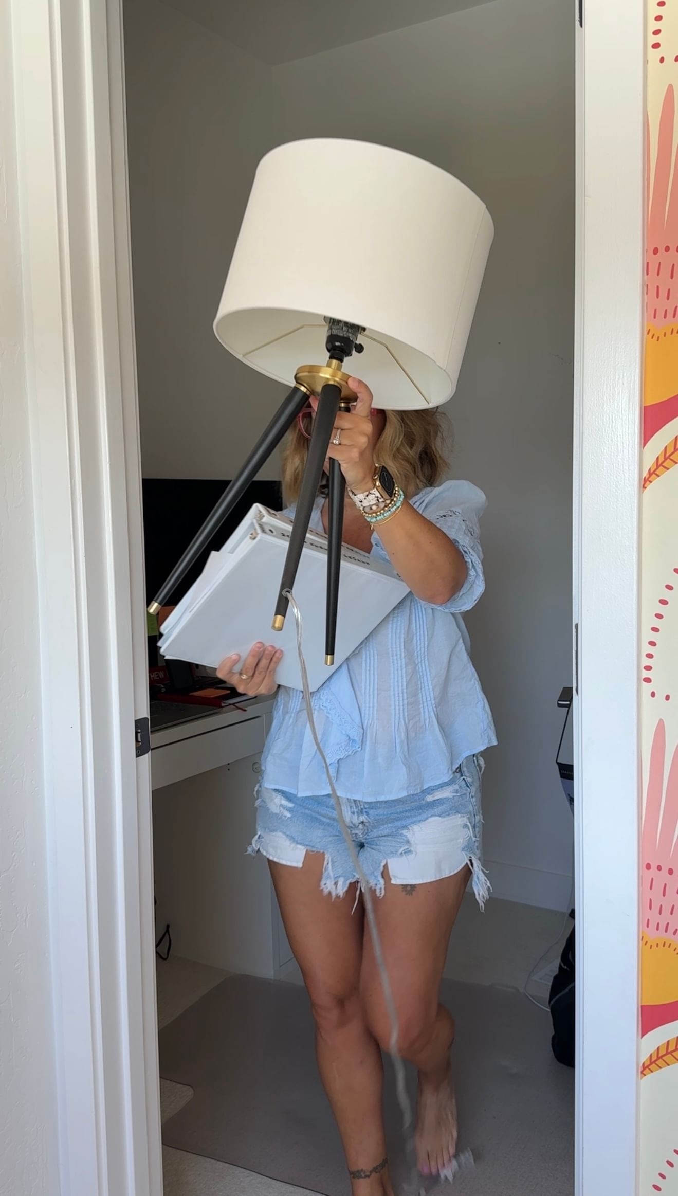 Woman carrying lamp out of small closet