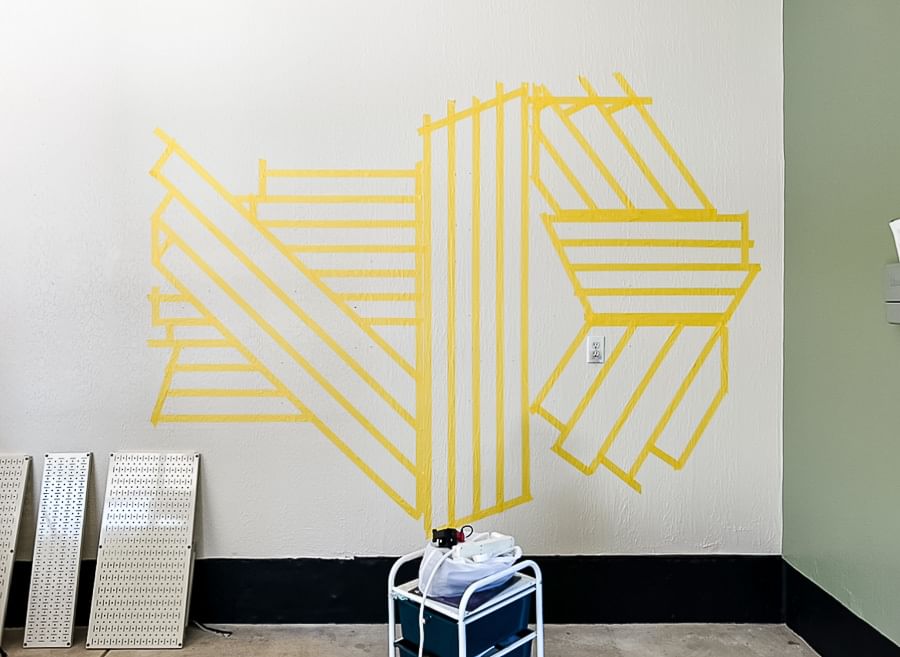 Yellow FrogTape Delicate Surface Painter's Tape taped in a pattern on a white garage wall.