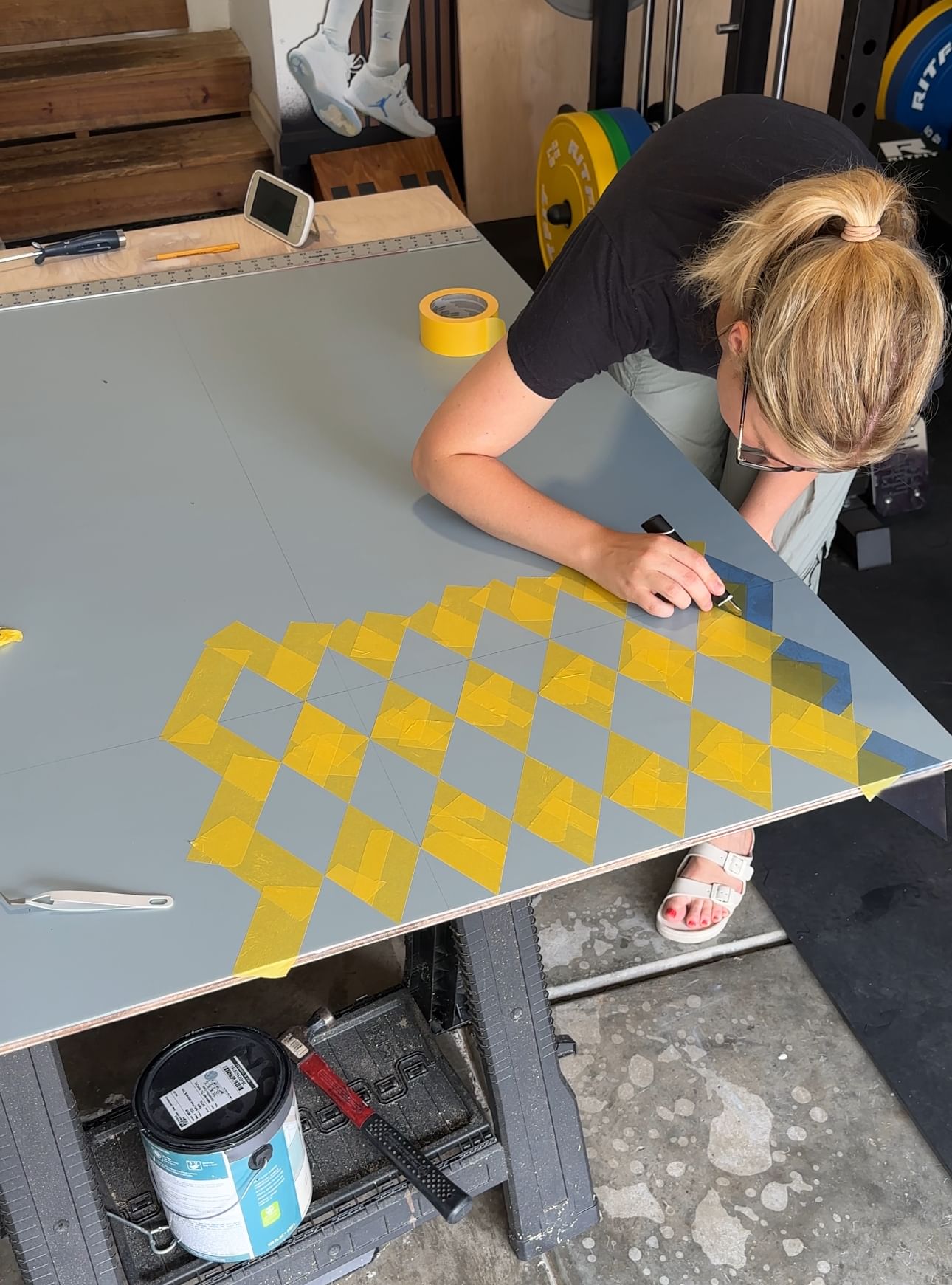 woman creating an Argyle pattern on drywall