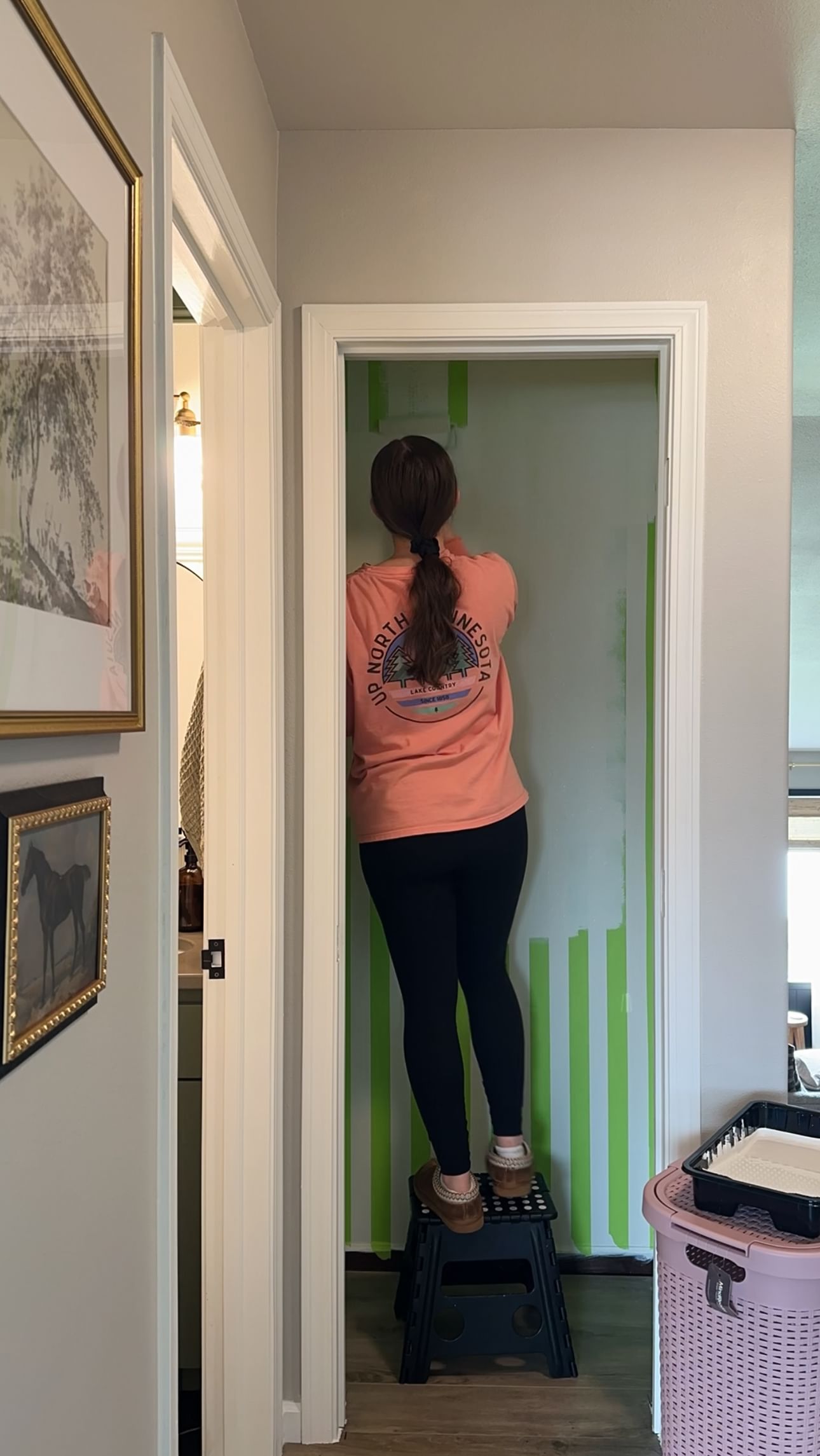 A woman painting the inside of a closet white