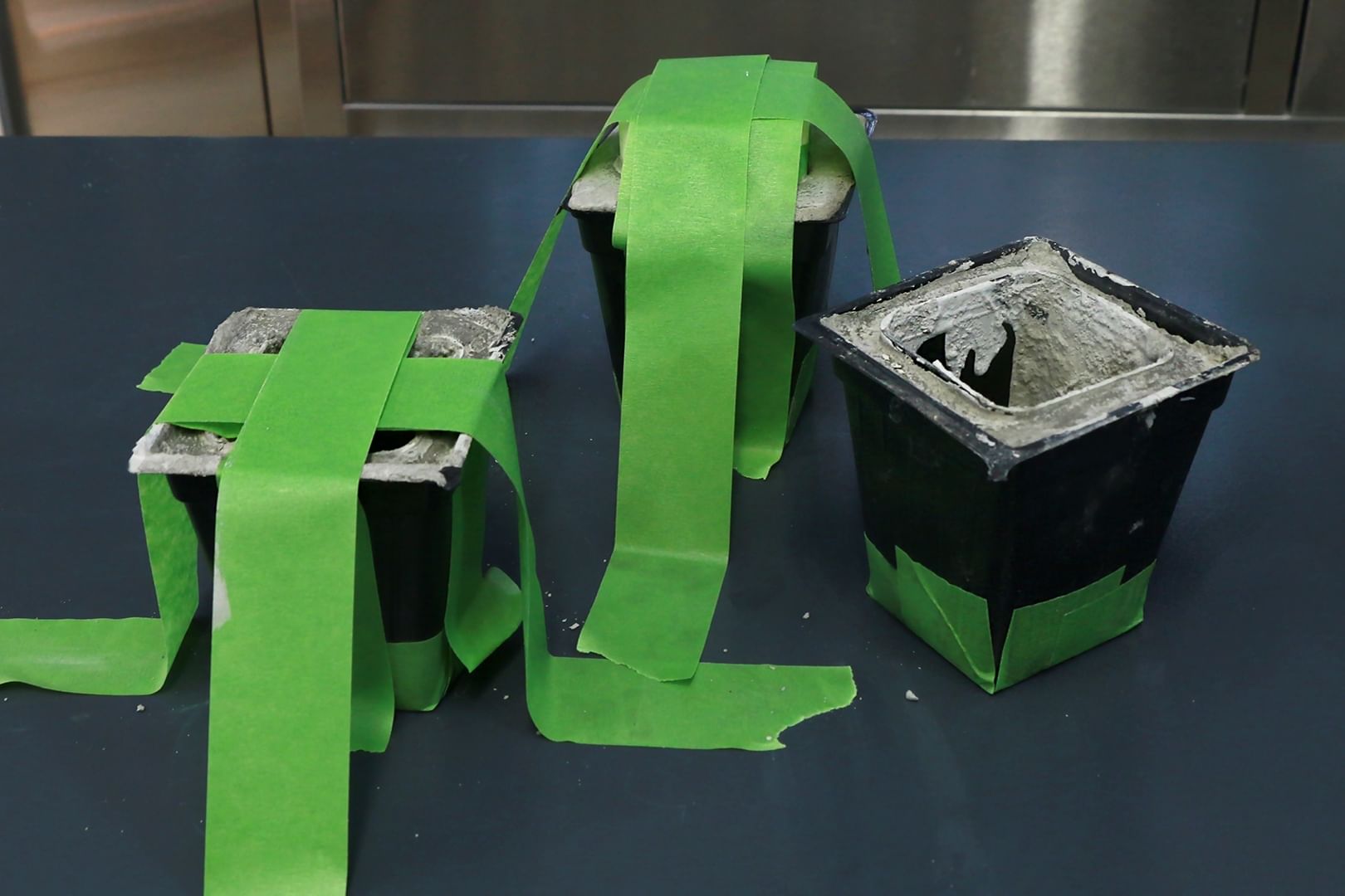 Black patterns with two pieces of tape placed over top of planter forming an X