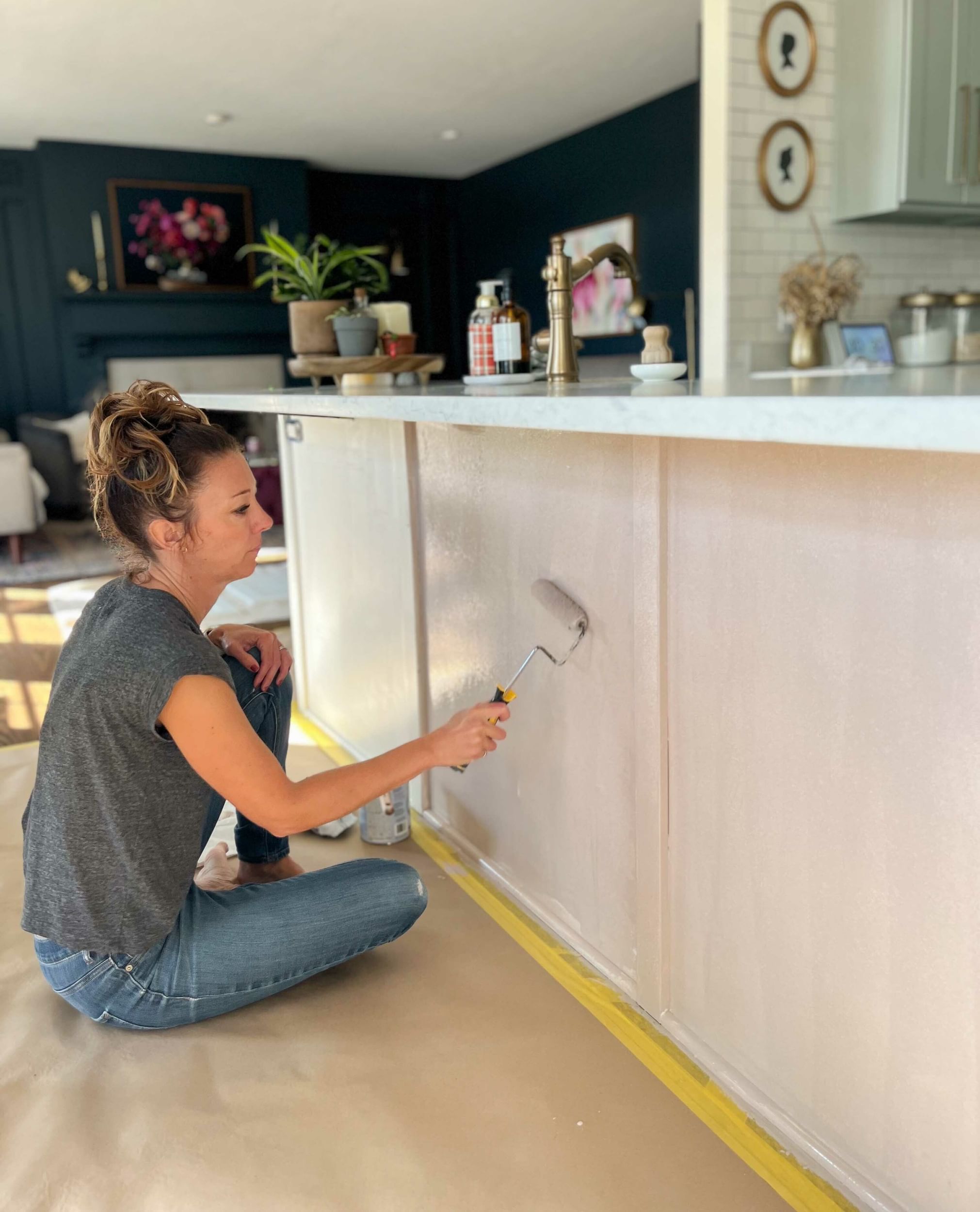 Woman painting the kitchen island