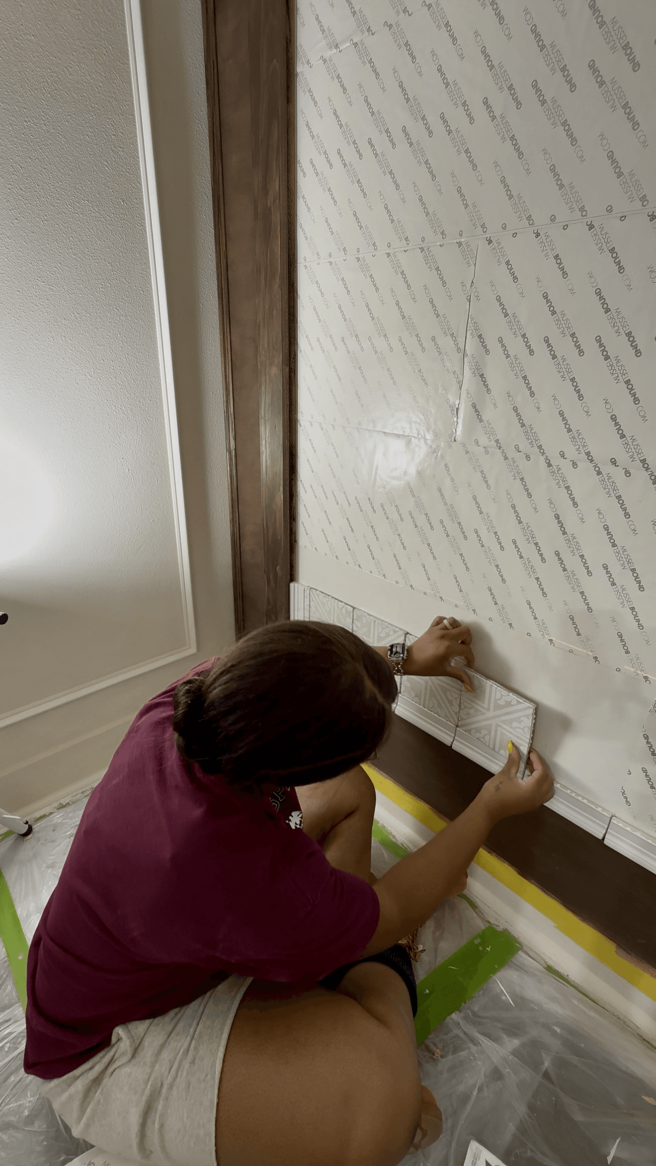 Woman installing tile wall