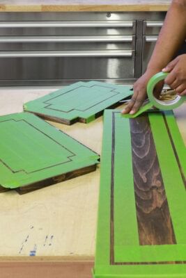 Green FrogTape Multi-Surface Painter's Tape being applied to wooden boards.