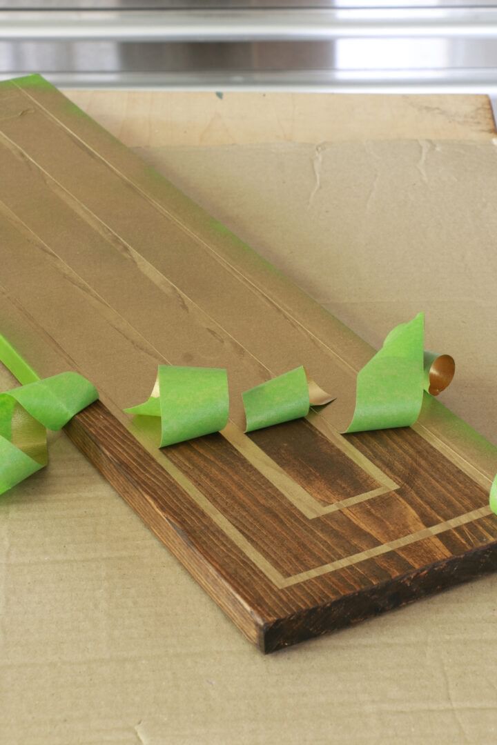 Green FrogTape Multi-Surface Painter's Tape peeled up from a wooden tray.