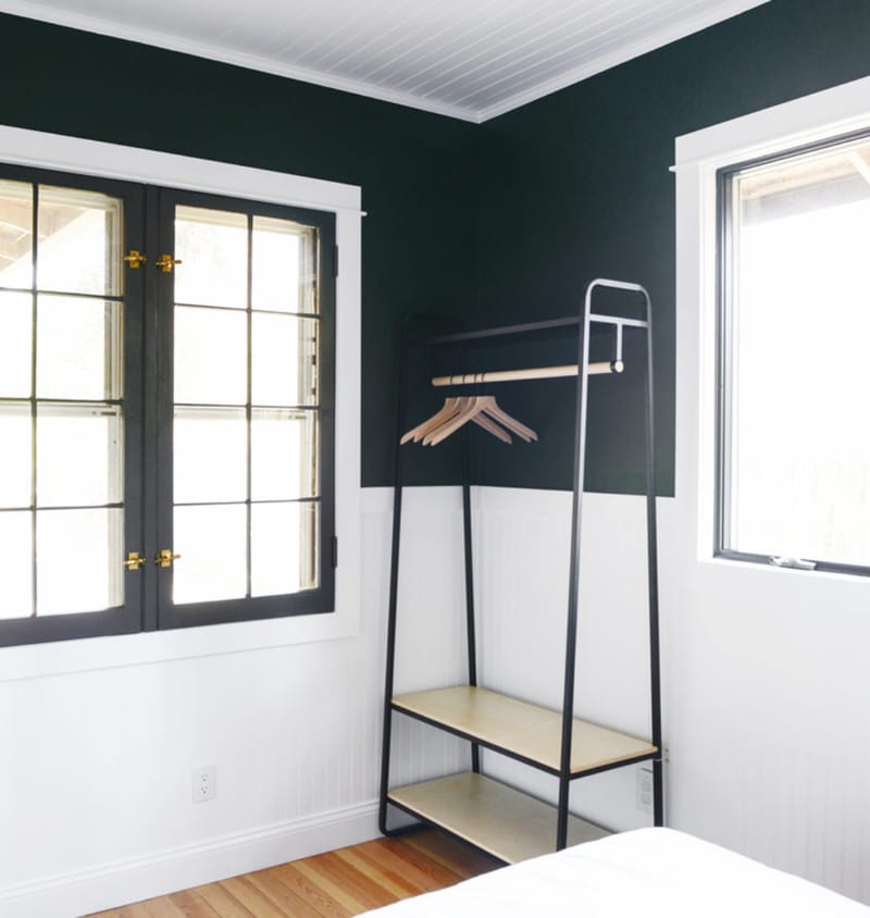 Room with large windows. The lower half of the walls in the room are white and the upper half are black.