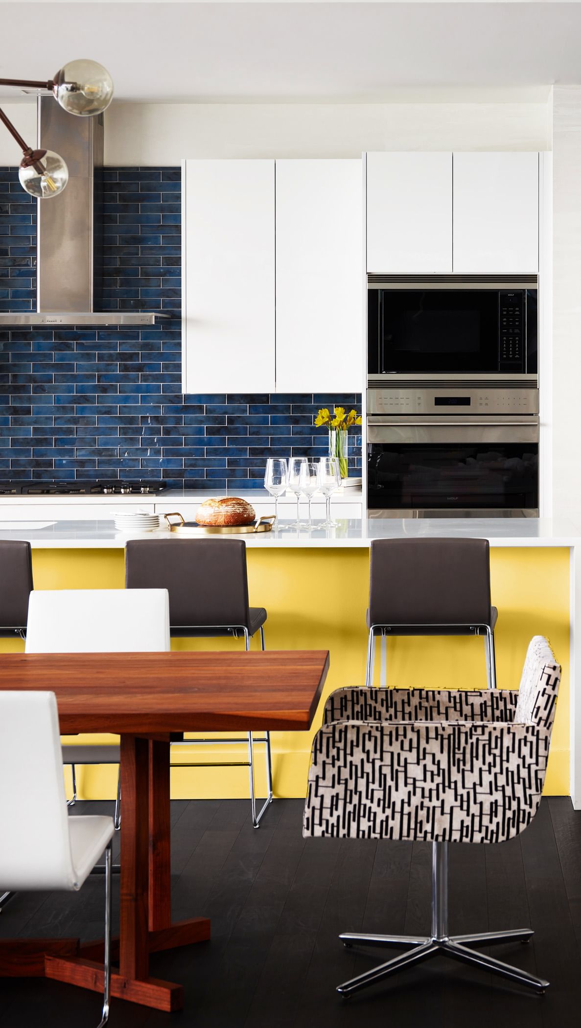 Modern white kicthen with blue backsplash and bright yellow island