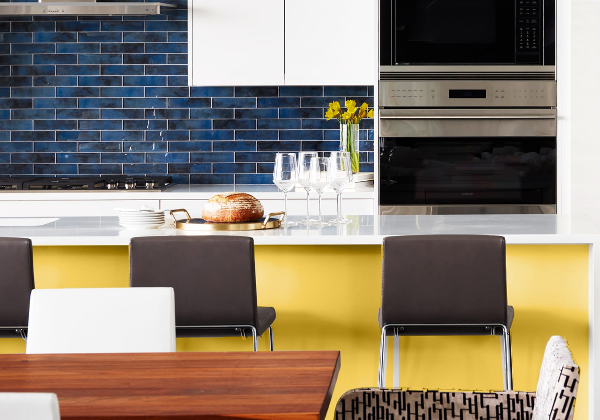 Modern white kicthen with blue backsplash and bright yellow island