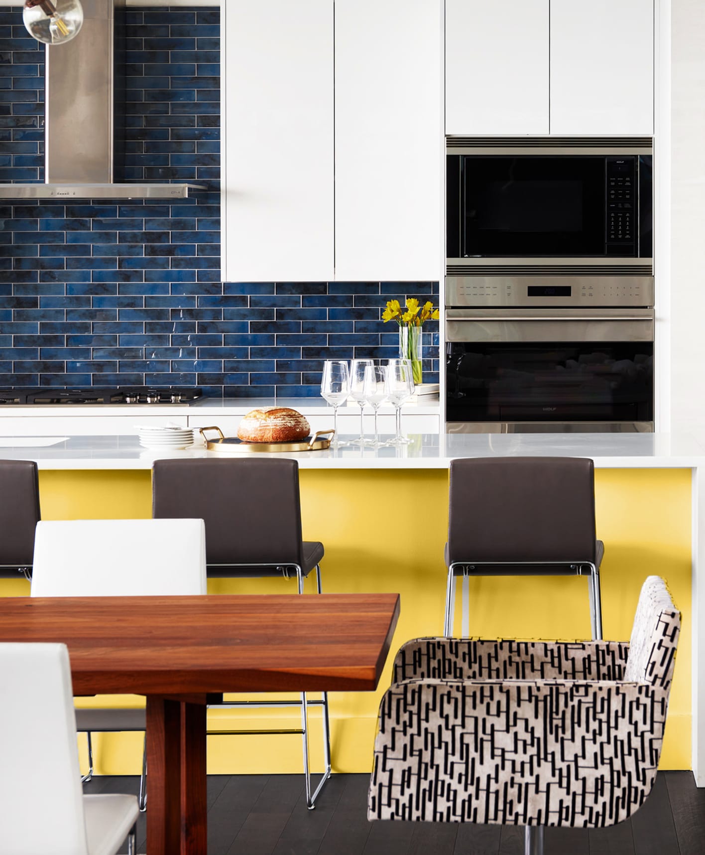 Modern white kicthen with blue backsplash and bright yellow island