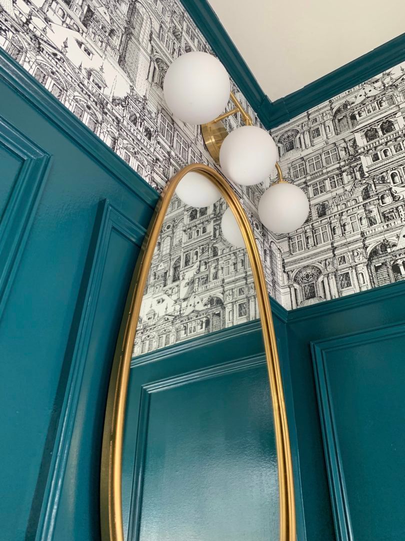 Dark aqua blue room with mirror with golden trim