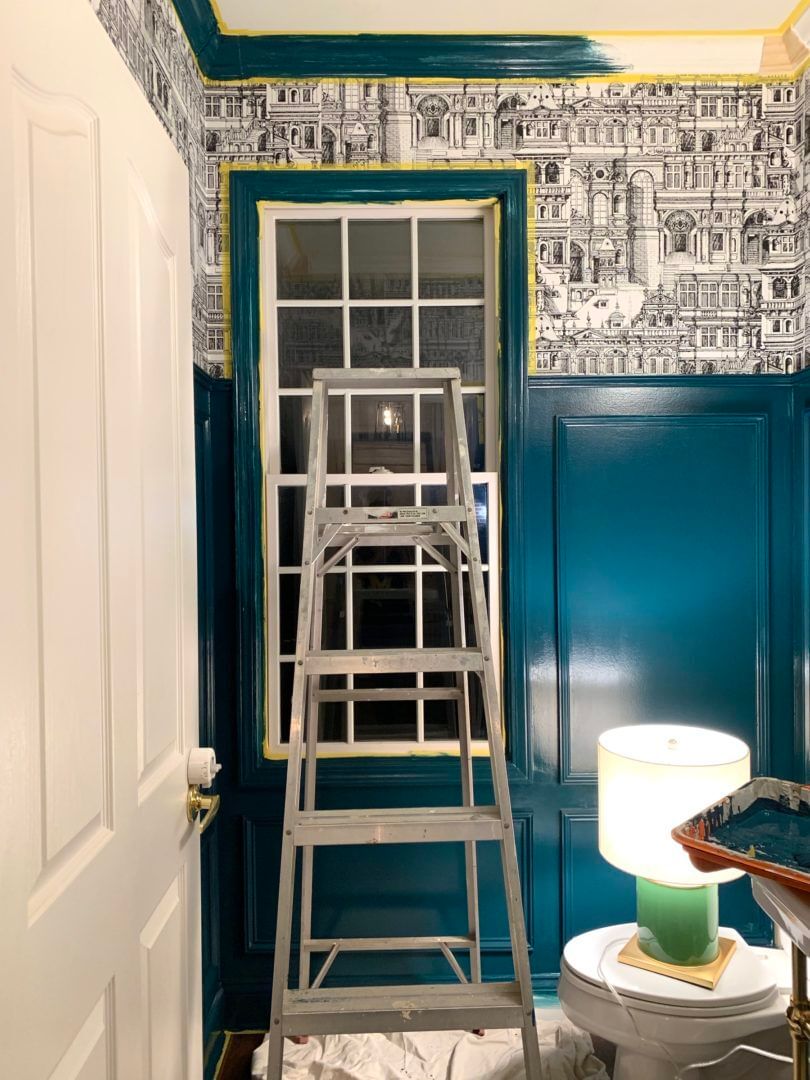 Bathroom being painted dark aqua blue. the window and trim are taped off with Yellow FrogTape Delicate Surface Painter's Tape.